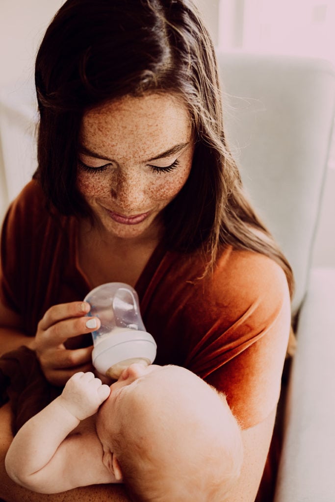 Newborn Photographer, a mother bottle feeds her baby